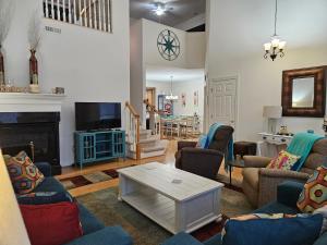ein Wohnzimmer mit Sofas, einem TV und einem Tisch in der Unterkunft Spectacular 3BR 2BA Bay Forest Villa near Bethany Beach! in Ocean View
