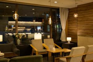 a dining room with chairs and tables and lights at Kotoni Green Hotel in Sapporo
