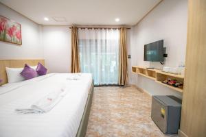 a hotel room with a large bed and a tv at Ratana Boutique Resort - Mae Phim in Ban Ang
