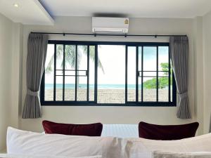 a bedroom with a bed and a view of the beach at Benjamin's Hut in Srithanu