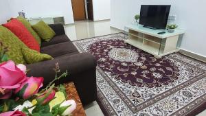 - un salon avec un canapé et une télévision dans l'établissement D'Lofa Homestay, à Bachok