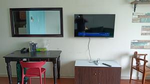 Zimmer mit einem Tisch und einem TV an der Wand in der Unterkunft Studio Apartment KTC KB in Kota Bharu