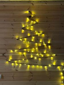 Un árbol de Navidad en una pared con luces en Cozy Hills en Borjomi