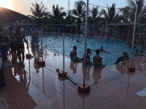 een groep mensen die rond een zwembad zitten bij DBI GUEST HOUSE in Lagos