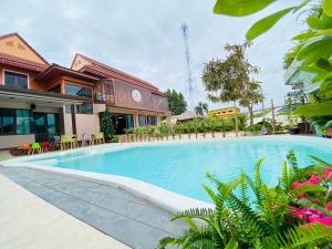 a swimming pool in front of a house at Ratana Boutique Resort - Mae Phim in Ban Ang