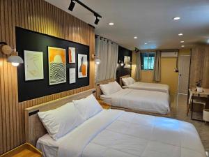 a hotel room with two beds and a desk at My Home Pool Villa Hatyai in Hat Yai