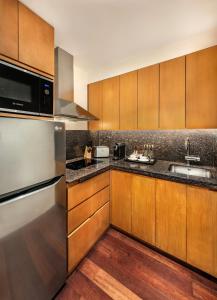 a kitchen with wooden cabinets and a sink at The H Dubai in Dubai