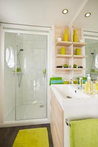 a bathroom with a shower and a white sink at Vakantiepark Koningshof in Rijnsburg