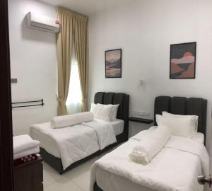 Ένα ή περισσότερα κρεβάτια σε δωμάτιο στο Homestay Muslim Gunung Rapat Ipoh