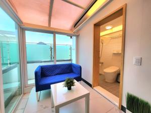 a room with a blue chair and a bathroom with a toilet at Seochon Dalbit in Seoul