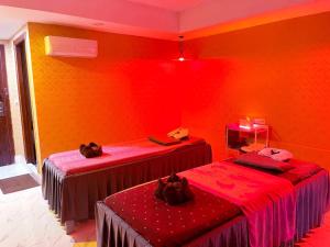 two beds in a room with red and orange walls at Sok Eng Hotel ( សណ្ឋាគារ សុខ អេង ) in Sihanoukville