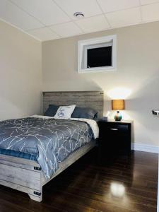 a bedroom with a bed and a tv on the wall at Gorgeous Apartment Serene Neighbourhood in Burlington