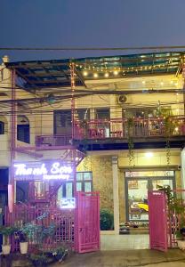 Thanh Sơn Homestay في كاو بانغ: مبنى بأبواب وردية وبلكونة