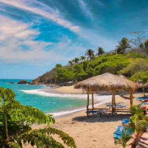 een strand met stoelen en parasols en de oceaan bij Punta Arena EcoHostal & EcoFit - Your Eco-Friendly Oasis in Playa Punta Arena