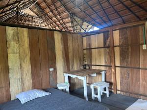 a room with a bed and a table in a room at Punta Arena EcoHostal & EcoFit - Your Eco-Friendly Oasis in Playa Punta Arena