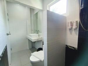 a white bathroom with a toilet and a sink at Krabi River Cottage Pool Villa in Ban Krabi Yai