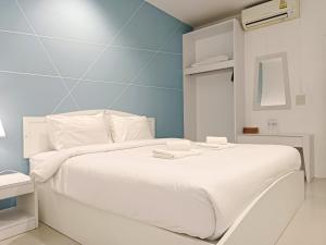 a bedroom with a white bed with a blue wall at Krabi River Cottage Pool Villa in Ban Krabi Yai