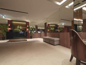 um lobby com uma sala de espera com plantas nas janelas em Hotel 1900 Express Chinatown em Singapura