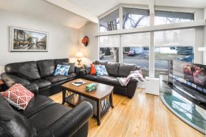 a living room with leather furniture and a flat screen tv at V-Home by Heritage park and Glenmore Reservoir in Calgary
