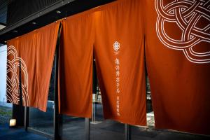 a group of orange curtains in a window at KAMENOI HOTEL Nikko Yunishigawa in Nikko