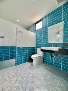 een blauwe badkamer met een toilet en een wastafel bij Napdown Resort Trat นับดาว รีสอร์ท ตราด in Trat