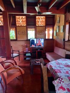 un soggiorno con letto e TV di CASA em UBATUBA a Ubatuba