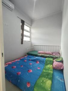 a bedroom with a bed with a comforter on it at Rumah Dekat Sawah Pemandangan Pegunungan in Kebumen