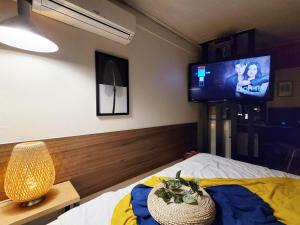 a bedroom with a bed with a tv on the wall at Residence YeoYu Uijeongbu Station in Uijeongbu