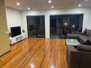 a living room with a couch and a television at Convenience & Luxury Apartment in Melbourne