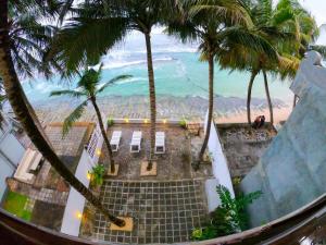 desde el balcón de un complejo con palmeras en Asa Bay Beach Resort, en Talpe