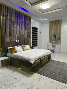 een slaapkamer met een groot bed en een stoel bij Affordable luxury 3bed apartment in Maiyegun