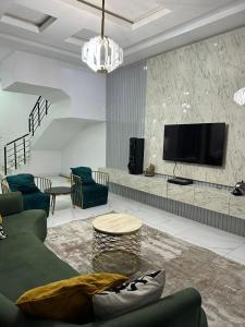 a living room with a couch and a tv at Affordable luxury 3bed apartment in Maiyegun