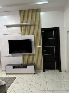 a living room with a flat screen tv on a wall at Affordable luxury 3bed apartment in Maiyegun