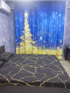 um quarto com uma árvore de Natal numa janela em Уютная студия 65/3 em Almaty