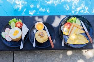 2 Teller mit Frühstückslebensmittel mit Eiern und Toast in der Unterkunft Kalpataru Cottage in Nusa Penida