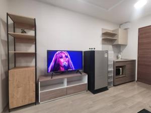 a living room with a tv and a refrigerator at Cozy room, BKK for short and long term rentals, 10mins walk to BTS, 25mins taxi to DMK airport in Ban Ko