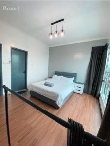 a bedroom with a white bed and a wooden floor at Sandakan Ijm pool view condo in Sandakan