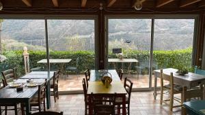 a restaurant with tables and chairs and a large window at Agriturismo La Contessa in Finale Ligure