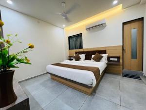 a bedroom with a large bed in a room at Hotel Venus By Mantram Hospitality in Rajkot