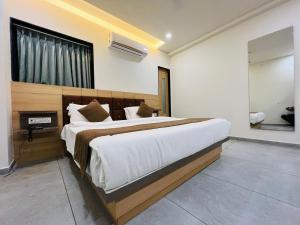 a bedroom with a large bed and a fireplace at Hotel Venus By Mantram Hospitality in Rajkot