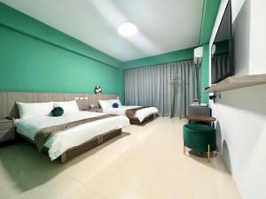 una camera da letto con due letti e una parete verde di NuNc a Kenting