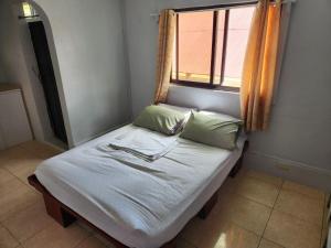 - un petit lit dans une chambre avec fenêtre dans l'établissement Beach Road Apartments, à Matabungkay