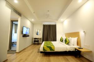 a hotel room with a bed and a desk at Hotel Rudra Inn At Chattarpur in New Delhi