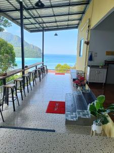 a room with chairs and tables and a view of the ocean at The view Hostel in Phi Phi Islands