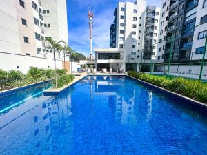 a large blue swimming pool in the middle of buildings at Apartamento Para Temporada in Ilhéus