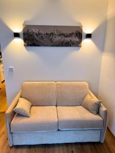 un divano in una stanza con un dipinto sul muro di Alpen Studio Ellmau II a Ellmau