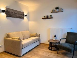 een woonkamer met een bank en een stoel bij Alpen Studio Ellmau II in Ellmau
