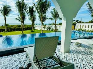 une terrasse avec une chaise et une piscine dans l'établissement Morocco Villa Mui Ne, à Phan Thiết 6 autres photos