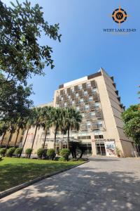 ein Gebäude mit Palmen davor in der Unterkunft West Lake 254D Hotel & Residence in Hanoi