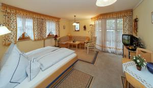 a bedroom with a large bed and a living room at Landhaus Cornelia in Bad Birnbach